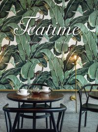Tea shop interior, table and chairs with white cups, saucers and glass teapot, tropical green wallpaper behind, Teatime in white font above.