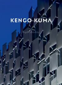 Colour photograph of a modern architectural building exterior illuminated at the bottom under a evening blue sky with Kengo Kuma in white with typography written upside down