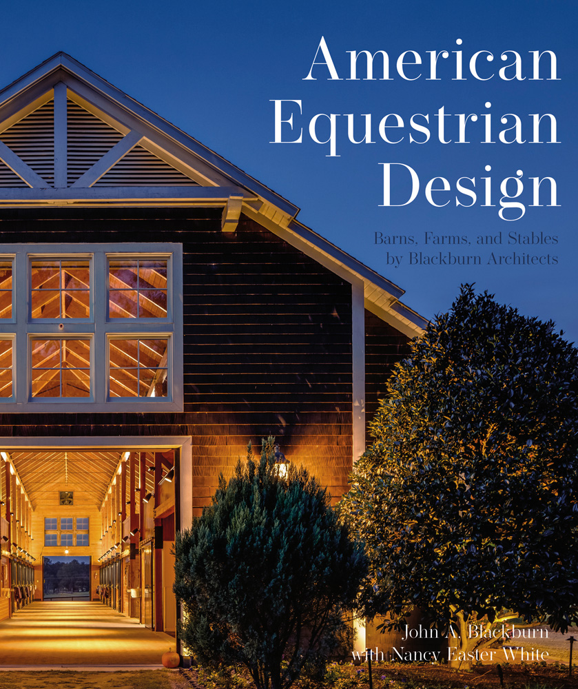 Colour photograph of a horse stable building entrance with two trees in the foreground and American Equestrian Design Barns, Farms, and Stables by Blackburn Architects in white and blue