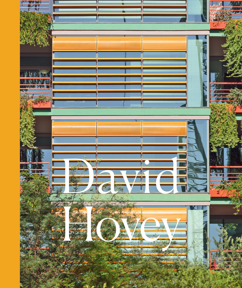 Close up of colourful architecture high rise building with orange window slats and green foliage cascading down window boxes and David Hovey in white font below