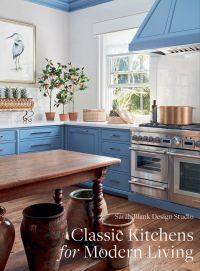 Kitchen interior space, blue fittings, wooden table, copper pan on hob, Classic Kitchens for Modern Living in white font to lower right corner