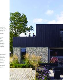 Book cover of British + Irish Modern: New Houses and Old Houses Made New with a large open door to interior, low table with purple alliums in vase, hanging light fittings. Published by Images Publishing.