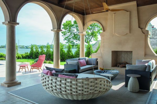 Book cover of On Interior Design featuring a beige interior space, with a sofa to centre, an open fire and hanging light fittings from ceiling. Published by Images Publishing.