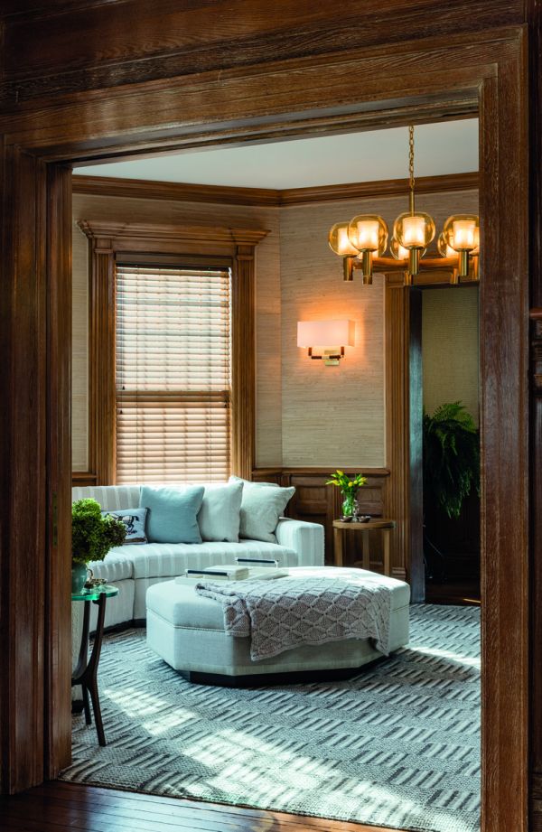 Book cover of On Interior Design featuring a beige interior space, with a sofa to centre, an open fire and hanging light fittings from ceiling. Published by Images Publishing.