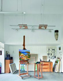 Artist sitting in wood studio, tree hammock in foreground, on green cover, Creative Spaces for Creative Ideas in white font above.