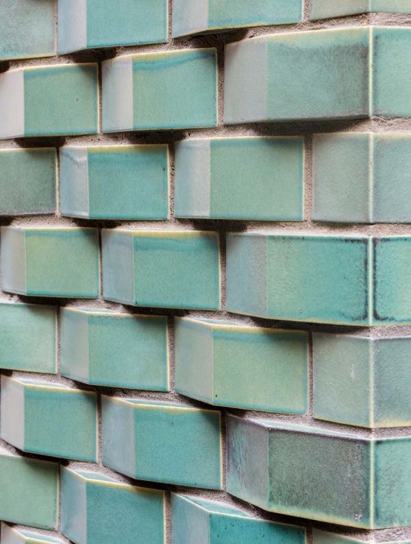 Latticed metal surface over brickwork, Brick Stone Metal Wood BUILDING ON TRADITION in white font to centre.