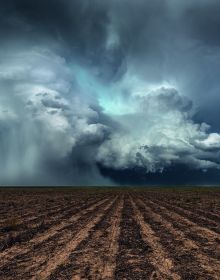 Atmospheric dark storm cloud above landscape, sun light to far left, FIERCE BEAUTY Storms of the Great Plains in white font above.