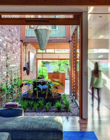 Modern exterior garden space with dining set, grey decking, Urban Oasis Tranquil Outdoor Spaces at Home in white font on grey banner to centre.