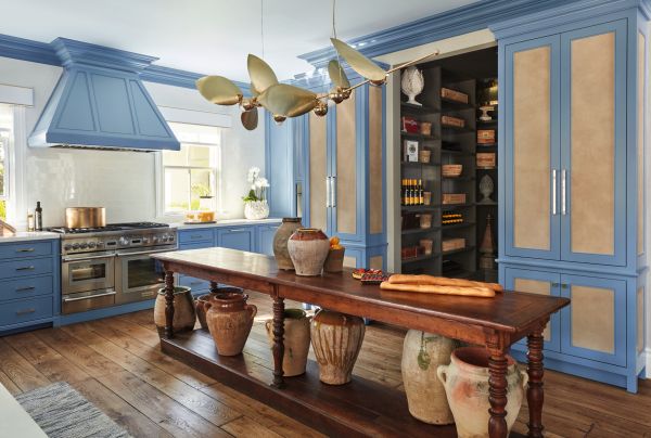 Book cover of Classic Kitchens for Modern Living, with a kitchen interior with blue fittings, a wooden table, and a copper pan on oven. Published by Images Publishing.