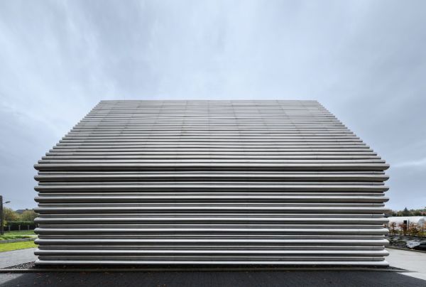 Book cover of Robert Konieczny: KWK Promes, buildings + ideas, with a modern family home resembling an ark, on green hillside. Published by Images Publishing.