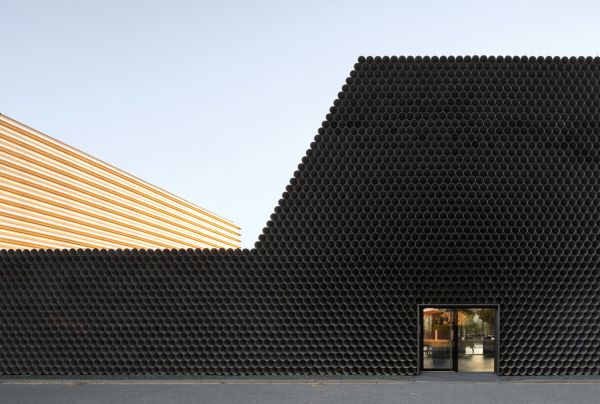 Book cover of Robert Konieczny: KWK Promes, buildings + ideas, with a modern family home resembling an ark, on green hillside. Published by Images Publishing.