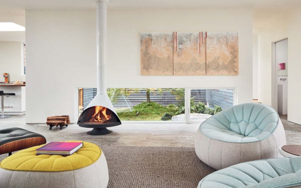 Book cover of Artists' Homes Designing Spaces for Living a Creative Life, with a bright open interior art studio space with artist sitting at painting easel. Published by Images Publishing.