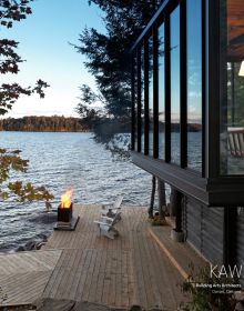 Book cover of Northern Hideaways, featuring a modern house with a flat roof of moss, poking out of the Canadian forest, with lake behind. Published by Images Publishing.