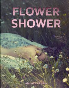 Low angle of daisies in prairie landscape, blurred image of nude female laying on front, FLOWER SHOWER Alexandra Sophie in pink metallic font