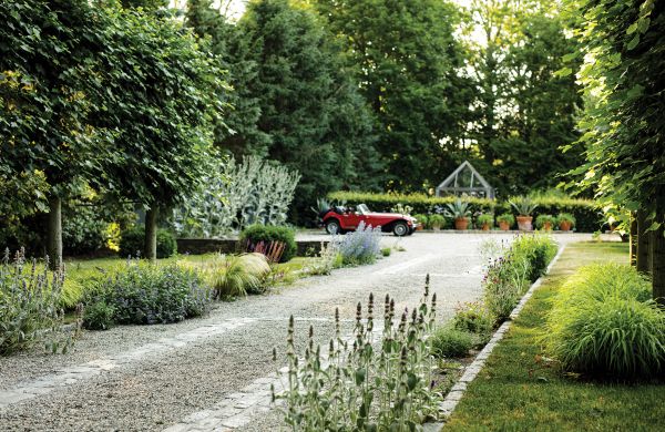Book cover of Intersection of Nature and Art: James Doyle Design Associates, featuring a landscaped garden with topiary hedge and sculpture of face. Published by Images Publishing.