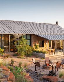 Modern residential home with flat roof, landscaped grounds, under purple sky, New Texas Modern, in white font above.