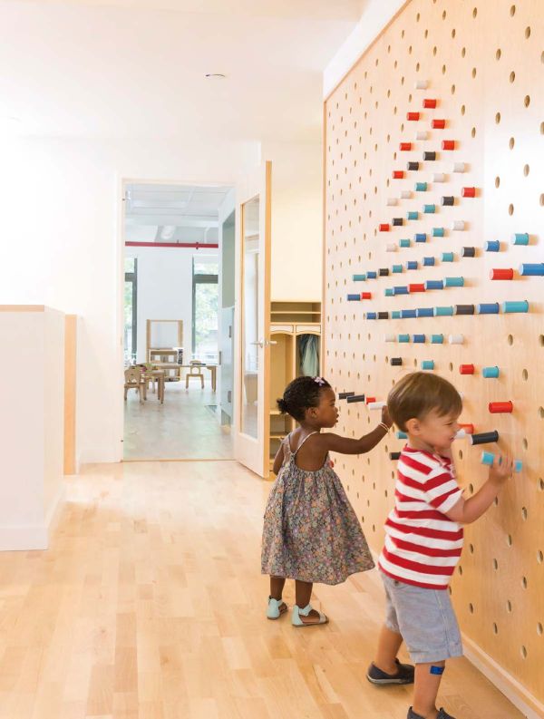 Book cover of Contemporary Creative Spaces for Children, featuring two boys playing on suspended multicoloured webbing. Published by Images Publishing.
