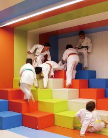 Book cover of Contemporary Creative Spaces for Children, featuring two boys playing on suspended multicolored webbing. Published by Images Publishing.