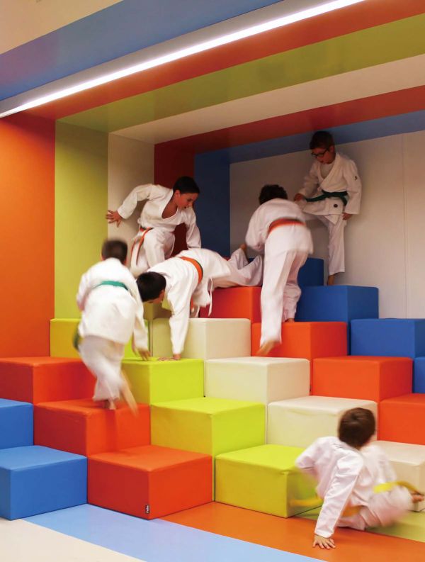 Book cover of Contemporary Creative Spaces for Children, featuring two boys playing on suspended multicoloured webbing. Published by Images Publishing.