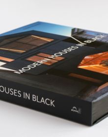 Book cover of Susan Redman's Modern Homes in Black, with a black wooden lake house in Berlin, surrounded by a garden. Published by Images Publishing.